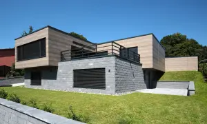 Nowoczesna bryła domu z kamienną podstawą i drewnianą fasadą. Elegancka fasada co to? To wizytówka budynku.