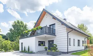 Nowoczesny biały dom z balkonem i zielenią. Idealny przykład darmowych projektów domów, które inspirują do budowy.