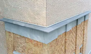 Nowoczesna attyka z cegły klinkierowej i metalowym wykończeniem.