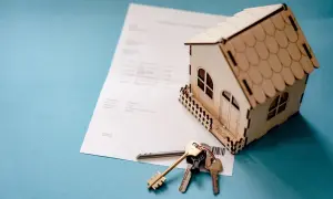 Model domu, klucze i dokumenty symbolizują refinansowanie kredytu hipotecznego.