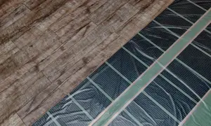 Drewniana podłoga obok instalacji ogrzewania podłogowego.