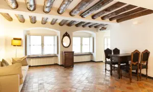 Stary salon z widocznymi belkami stropowymi i podłogą z terakoty. Co to za materiał?