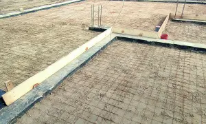 Fundament pod budowę domu, zbrojenie gotowe do zalania betonem. Widać drewniane szalunki i rury. Czekamy na chudziak.