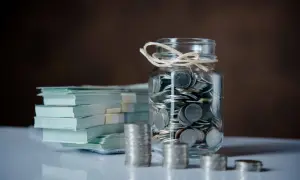 Skarbonka pełna monet i stos banknotów. Niespodziewana darowizna od obcej osoby, która może zmienić przyszłość.