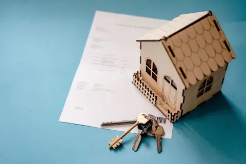 Model domu, klucze i dokumenty symbolizują refinansowanie kredytu hipotecznego.
